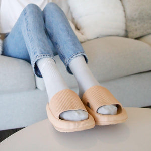 Grey socks in tan slippers on living room table